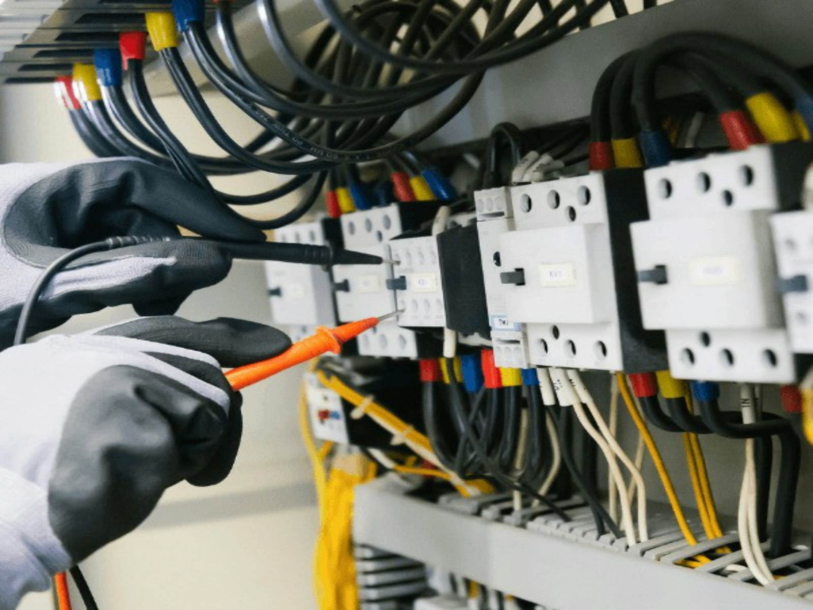 Engineer testing signals inside an electrical control panel